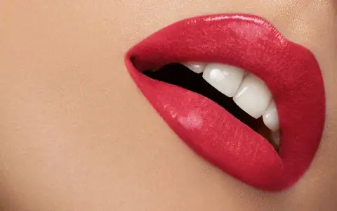 Primo piano labbra femminili con rossetto rosso.