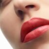 Primo piano di labbra donna con rossetto rosso.